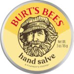 Burt’s Bees Hand Salve tin container with yellow label and farmer illustration, 85g.