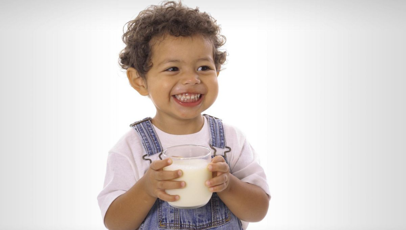 Smiling child drinking milk for healthy growth and bone development