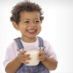 Smiling child drinking milk for healthy growth and bone development
