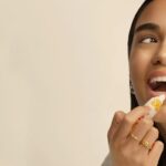 Woman applying natural lip balm on lips for hydration and smooth lip care routine