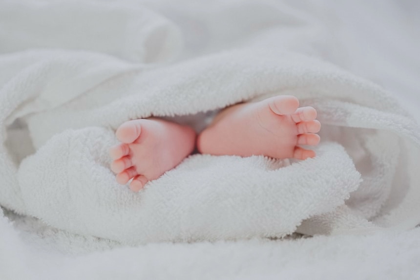 newborn baby feet wrapped in blanket best baby care products essential